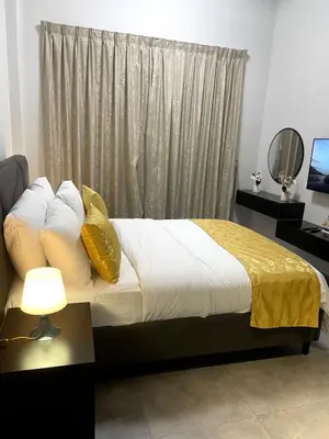 a bedroom with a bed with yellow pillows and a window at Ista Vacation Homes LLC in Dubai