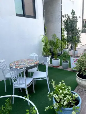 a patio with a table and chairs and potted plants at Ista Vacation Homes LLC in Dubai