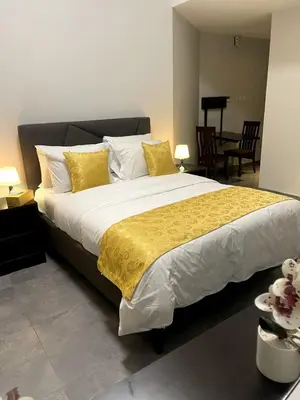 a bedroom with a large bed with yellow and white pillows at Ista Vacation Homes LLC in Dubai