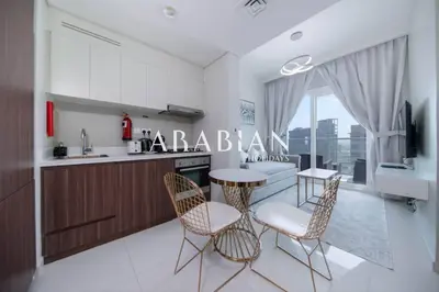 a kitchen with a table and chairs and a counter at Cozy 1BR Apartment with Balcony in Business Bay in Dubai