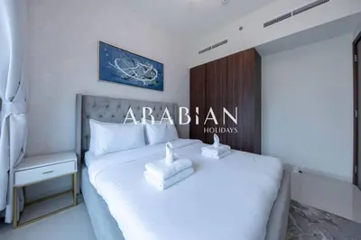 a bedroom with a white bed with a sign on it at Cozy 1BR Apartment with Balcony in Business Bay in Dubai