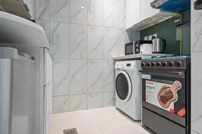 a kitchen with a stove and a washing machine at Stylish Studio Near Dubai Academic City in Dubai