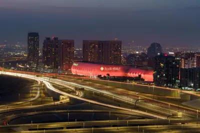 a city skyline at night with a highway and buildings at Stylish Studio Near Dubai Academic City in Dubai