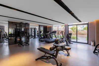 a gym with many treadmills and machines in it at Waves - Comfortable JVC Apt with Balcony and Maids Room in Dubai