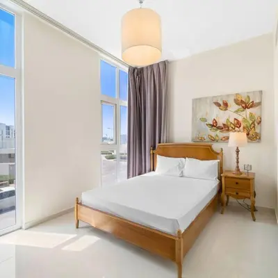a bedroom with a bed and a large window at Modern 3-Bedroom Villa in Damac Hills 2 in ‘Ūd al Bayḑāʼ