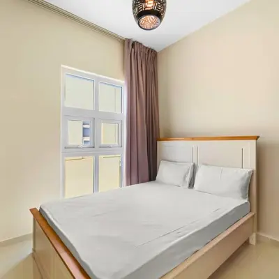 a bedroom with a large bed with a window at Modern 3-Bedroom Villa in Damac Hills 2 in ‘Ūd al Bayḑāʼ