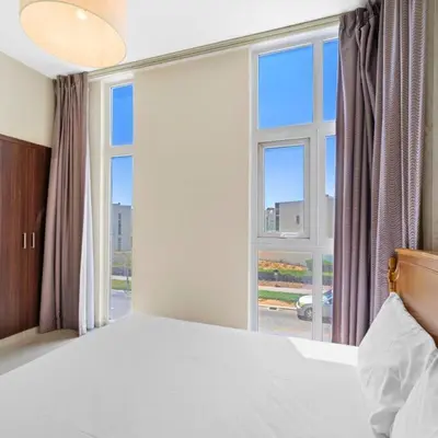 a bedroom with a bed and a large window at Modern 3-Bedroom Villa in Damac Hills 2 in ‘Ūd al Bayḑāʼ