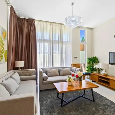 a living room with a couch and a table at Modern 3-Bedroom Villa in Damac Hills 2 in ‘Ūd al Bayḑāʼ