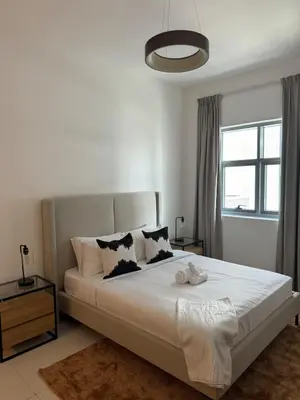 a bedroom with a large white bed with a window at Brand New JVC 1 bed - sleeps 4 in Dubai