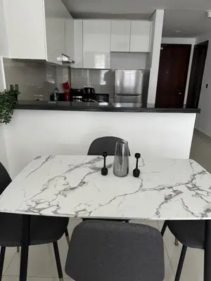 a kitchen with a marble table and chairs at Brand New JVC 1 bed - sleeps 4 in Dubai