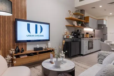 a living room with a flat screen tv on a wall at Dubai Hills - 1BR Luxe Apartment - Golfville - by UDH in Dubai