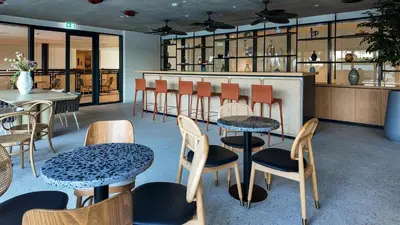 a restaurant with tables and chairs and a counter at Dubai Hills - 1BR Luxe Apartment - Golfville - by UDH in Dubai