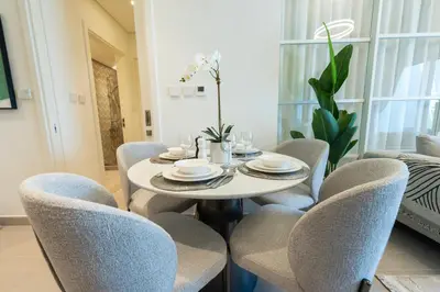 a dining room with a table and chairs at Dubai Hills - 1BR Luxe Apartment - Golfville - by UDH in Dubai