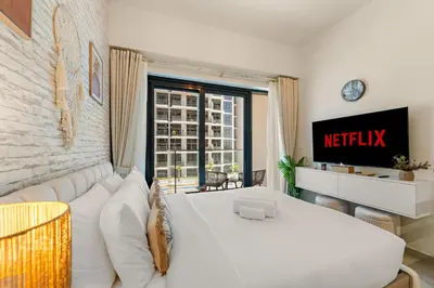 a living room with a white couch and a window at Lovely Apt Near The Burj with Pool, Gym & BBQ Area in Dubai