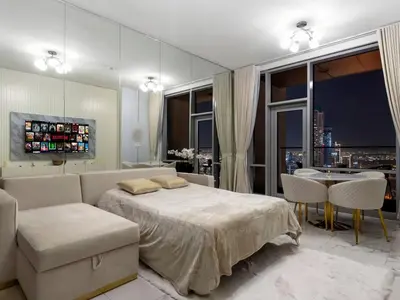 a bedroom with a large bed and a dining room at Luxury Apt in Business Bay Water canal view in Dubai