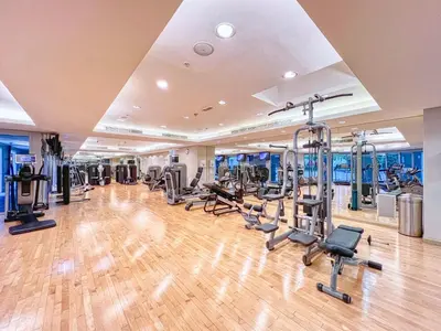 a gym with several treadmills and cardio machines at Cozy 1-Bedroom Apartment at Heart of Dubai in Dubai