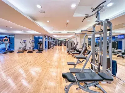 a gym with treadmills and elliptical machines at Cozy 1-Bedroom Apartment at Heart of Dubai in Dubai