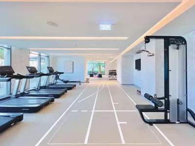 a gym with rows of treadmills and machines at Seaside Lux Retreat 2-BR Private Beach in Dubai