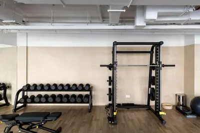 a gym with a rack of weights at Waves - Refined Studio with Balcony & City Views in Luma21 in Dubai