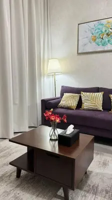 a living room with a purple couch and a coffee table at Home away from home in Dubai