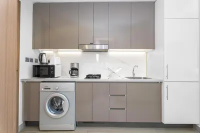 a kitchen with a washing machine and a sink at Escape24 Studio at Azizi Riviera near Business Bay in Dubai