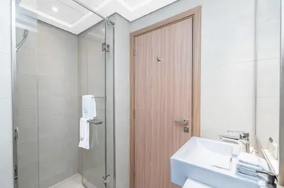 a bathroom with a shower and a sink and a mirror at Escape24 Studio at Azizi Riviera near Business Bay in Dubai