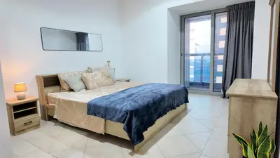 a bedroom with a bed and a large window at Luxury OneBedroom Apartment next to Barasti Beach in Dubai