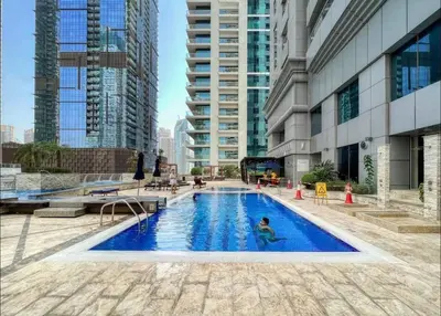 a person swimming in a pool in a building at Luxury OneBedroom Apartment next to Barasti Beach in Dubai