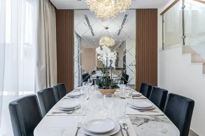 a dining room with a table with chairs and a chandelier at NewArabian Sidra1 -4 BR & Maid in Dubai