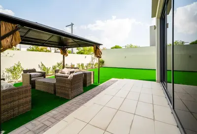 an outdoor patio with wicker furniture and green grass at NewArabian Sidra1 -4 BR & Maid in Dubai