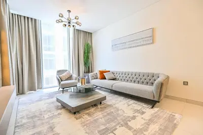 a living room with a couch and a table at Stunning 1BR Retreat with Crystal Lagoon Views! in Dubai