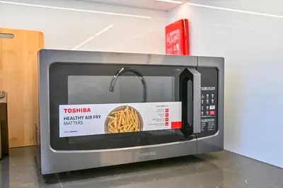 a microwave with a picture of a pasta inside at Stunning 1BR Retreat with Crystal Lagoon Views! in Dubai