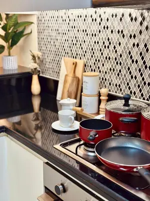a kitchen counter with pots and pans on a stove at Paramount Midtown I Sky High Luxury 2BR Apartment with Burj Khalifa View & Highest Infinity Pool I Down Town Dubai in Dubai
