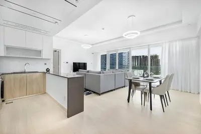 a kitchen and living room with a table and chairs at Stylish Brand New 1 Bedroom in Dubai