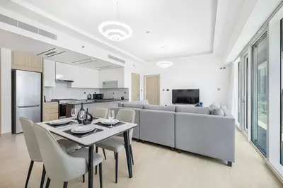 a living room with a table and a couch at Stylish Brand New 1 Bedroom in Dubai