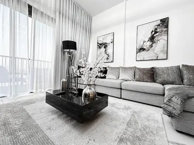 a living room with a couch and a table with flowers at Upgraded 1BDR APT in Mag 930 , AL Merkadh Dubai in Dubai