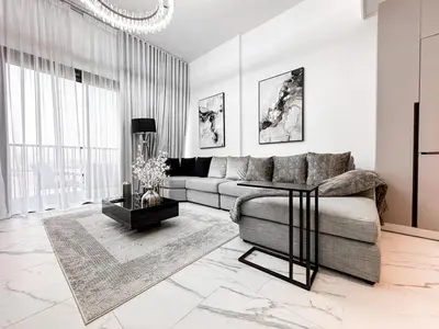 a living room with a couch and a table at Upgraded 1BDR APT in Mag 930 , AL Merkadh Dubai in Dubai