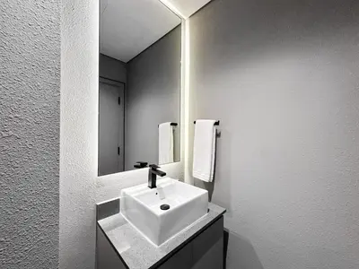 a white bathroom with a sink and a mirror at Upgraded 1BDR APT in Mag 930 , AL Merkadh Dubai in Dubai