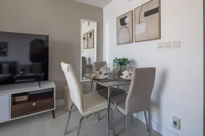 a dining room with a table and chairs and a television at Frank Porter - Lakeside Tower C in Dubai