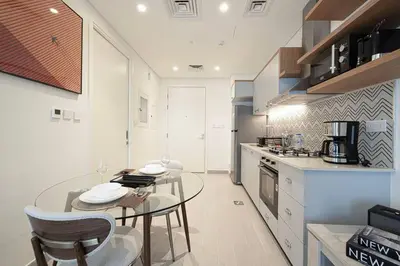 a kitchen with a glass table and two chairs at Cozy 1 - Bedroom Retreat in DHE in Dubai