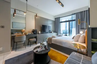 a hotel room with a king sized bed and a desk at Canal View Studio - 10 min to Dubai Mall - MAG 318 in Dubai