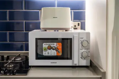 a microwave sitting on top of a counter next to aokuokuokuokuoku at Canal View Studio - 10 min to Dubai Mall - MAG 318 in Dubai