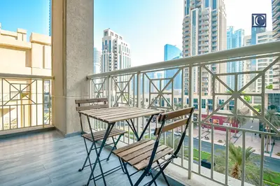 a table and chairs on a balcony with a view of a city at Luxury Escapes - Elegant 3BR Apt with 4 Balconies in 29 Blvd in Dubai