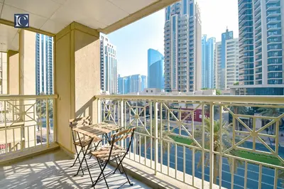 a balcony with two chairs and a view of a city at Luxury Escapes - Elegant 3BR Apt with 4 Balconies in 29 Blvd in Dubai