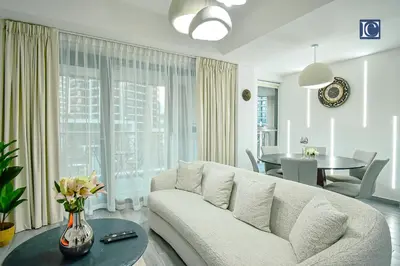a white living room with a couch and a table at Luxury Escapes - Elegant 3BR Apt with 4 Balconies in 29 Blvd in Dubai