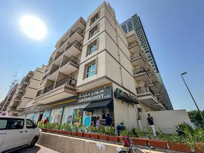 a building on a street with a car parked in front at Marco Polo - Experience elegant living in JVC Dubai in Dubai
