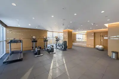 a gym with cardio equipment in a large room at Damac Hills Carson studio on Golf Course in Dubai Marina