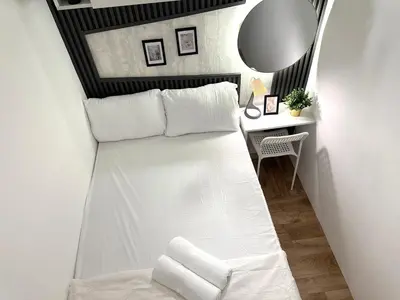 a white bed in a room with a mirror at Executive Suite Room in Barsha 1 Near MOE Metro in Dubai