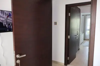 a wooden door in a room with a hallway at Specious 2BR VILLA WITH MAIDROOM AND HUGE GARDEN IN JVT DUBAI in Dubai