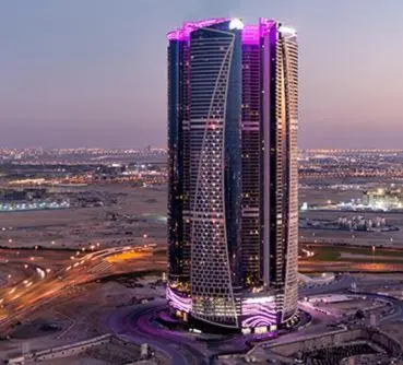 a tall building with purple lights on top of it at DAMAC Towers by Paramount Hotels & Resorts Dubai in Dubai